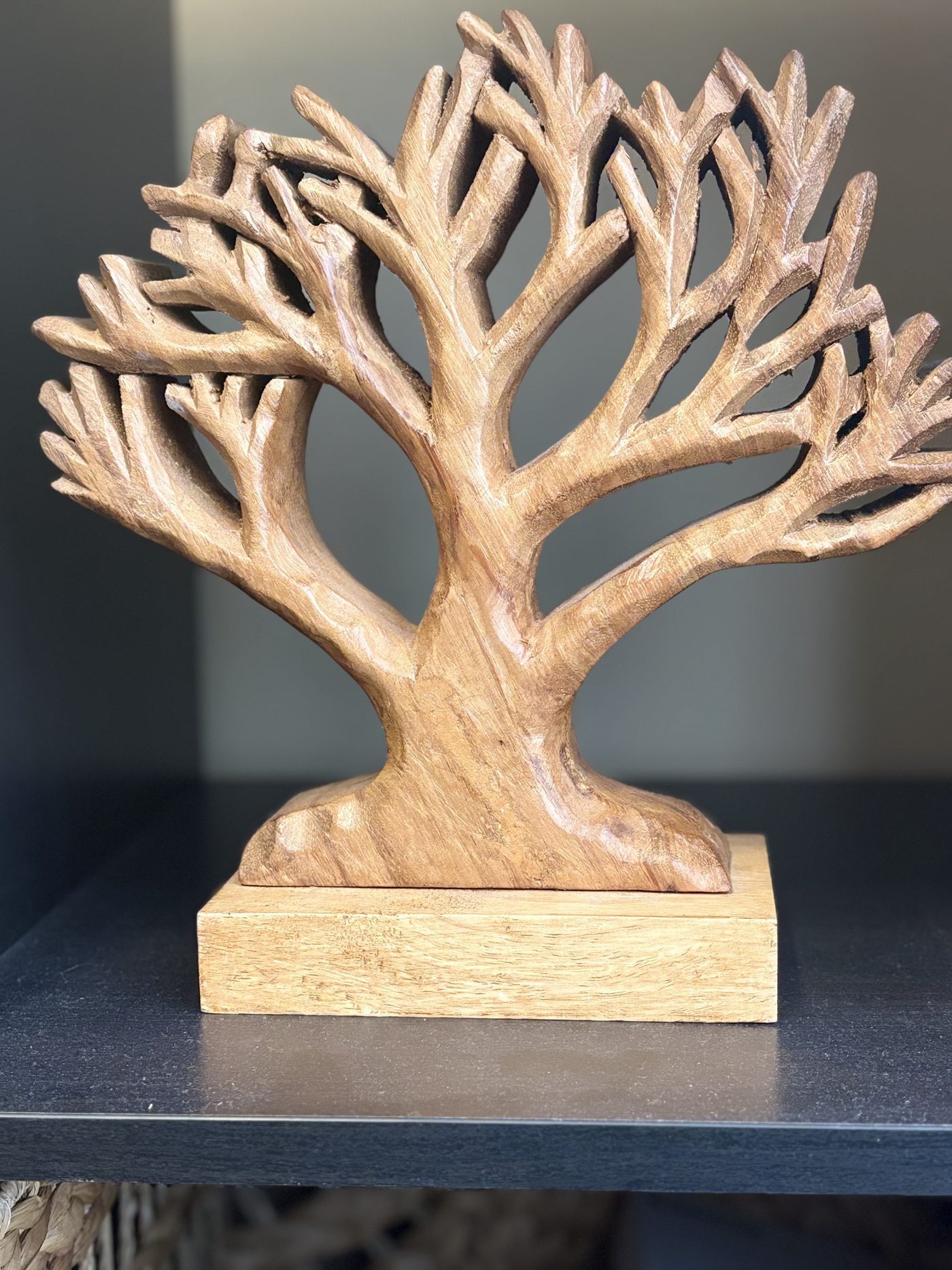 A carved wooden tree on a shelf in the Sorrel office