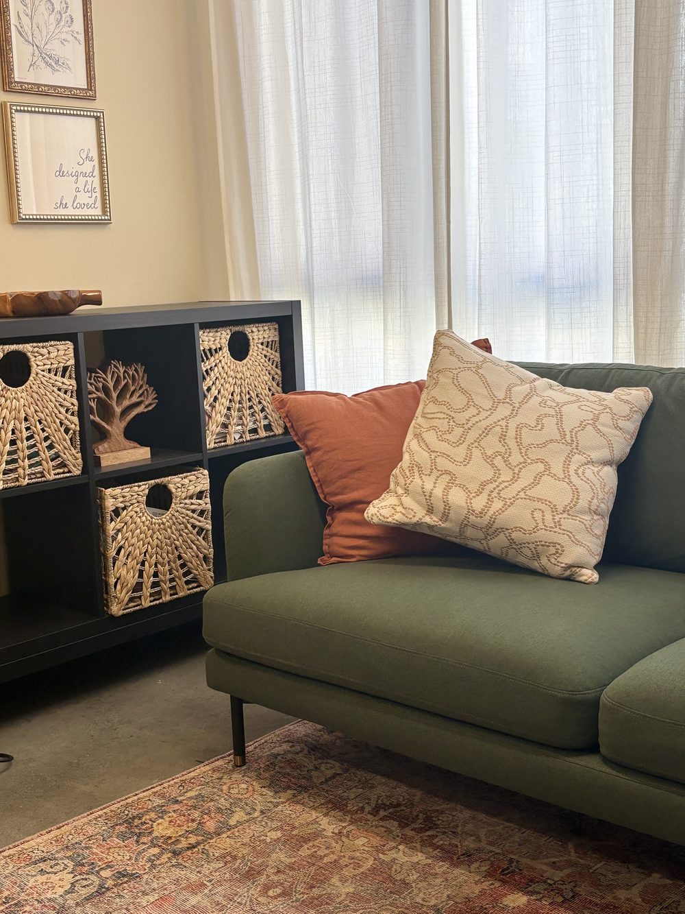 The Sorrel consulting room: a green sofa with terracotta and cream cushions beside a patterned cabinet